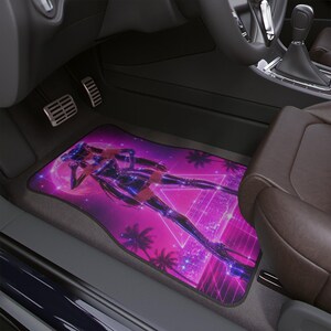Könnte beinhalten: Eine rechteckige Autofußmatte mit einem lebendigen violetten und pinken Grafikdruck einer stilisierten Roboterfigur vor einer Kulisse aus Palmen, einem großen Mond und einem leuchtenden Dreieck in einem futuristischen Stadtbild.