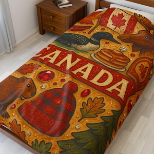 Könnte beinhalten: Eine Bettdecke mit kanadischem Thema in Rot- und Goldtönen. Das Design umfasst eine kanadische Flagge, einen Elch, eine Eistaucher, Ahornblätter, eine rot-schwarz karierte Mütze und das Wort "CANADA".