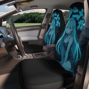 May include: Black car seat covers with a teal anime girl illustration. The design includes long teal hair, a black dress, and Japanese text. The covers are installed in a car interior with a steering wheel and dashboard visible.