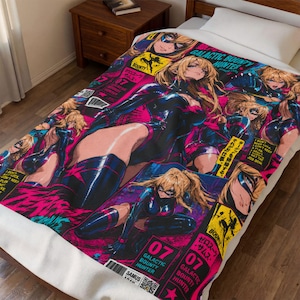 May include: A colorful blanket featuring a comic book style illustration of a female character in a black bodysuit. The design includes the text "GALACTIC BOUNTY HUNTER" and "07". The blanket is primarily pink, black, and blue.