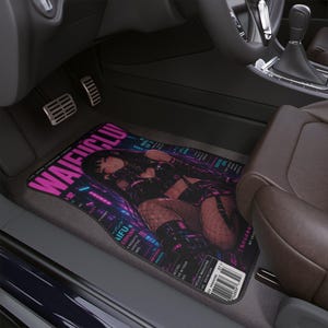 May include: A rectangular car floor mat featuring a vibrant graphic print of an anime-style character in a black outfit with fishnet stockings. The design includes bold pink text reading WAIFUCLU, various Japanese characters, and a barcode graphic.