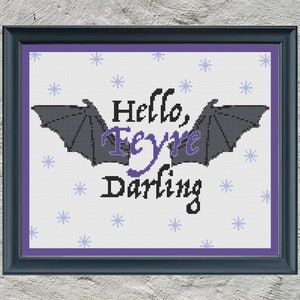 Puede incluir: Patrón de punto de cruz con un par de alas de murciélago con el texto "Hello, Feyre Darling" en letras moradas sobre un fondo blanco con copos de nieve azules.