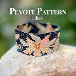 Può includere: Un braccialetto di perline con un motivo floreale. Il braccialetto presenta un motivo di gigli in rosa, oro e azzurro su uno sfondo blu scuro. Il testo "Peyote Pattern Lilies" è visualizzato sopra il braccialetto.