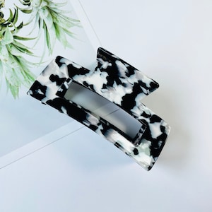 May include: Black and white marbled plastic hair claw clip.