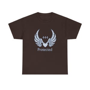 Könnte beinhalten: Dunkelbraunes T-Shirt mit weißer Grafik von Engelsflügeln, einem Herzen und der Zahl "444". Das Wort "Protected" steht unter dem Herzen. Das Shirt ist aus weichem Material und hat einen klassischen Rundhalsausschnitt.