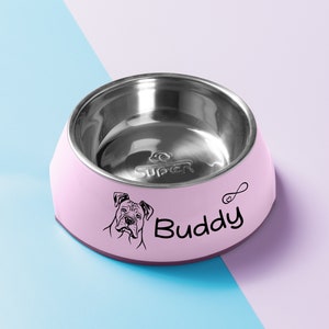 May include: Pink stainless steel pet bowl with a black silhouette of a dog and the name "Buddy" printed on the side.
