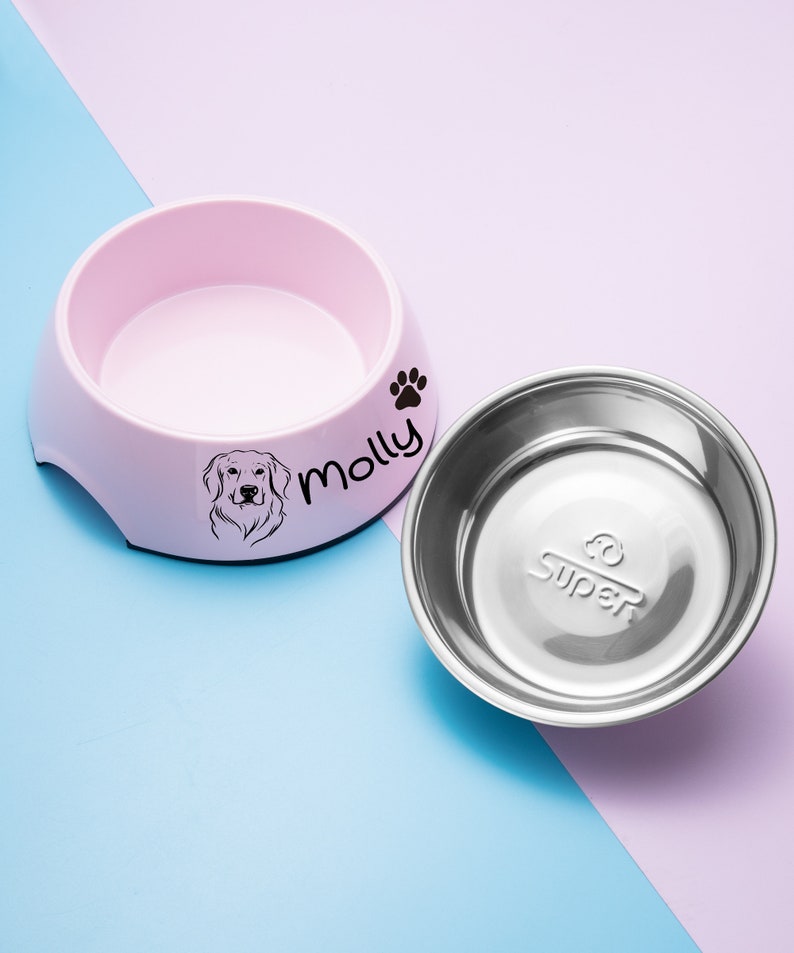 May include: Pink and white dog bowl with a stainless steel insert. The bowl has a paw print and the name "Molly" printed on it.