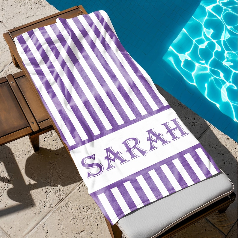 Puede incluir: Toalla de playa a rayas moradas y blancas con el nombre "SARAH" en una fuente decorativa.