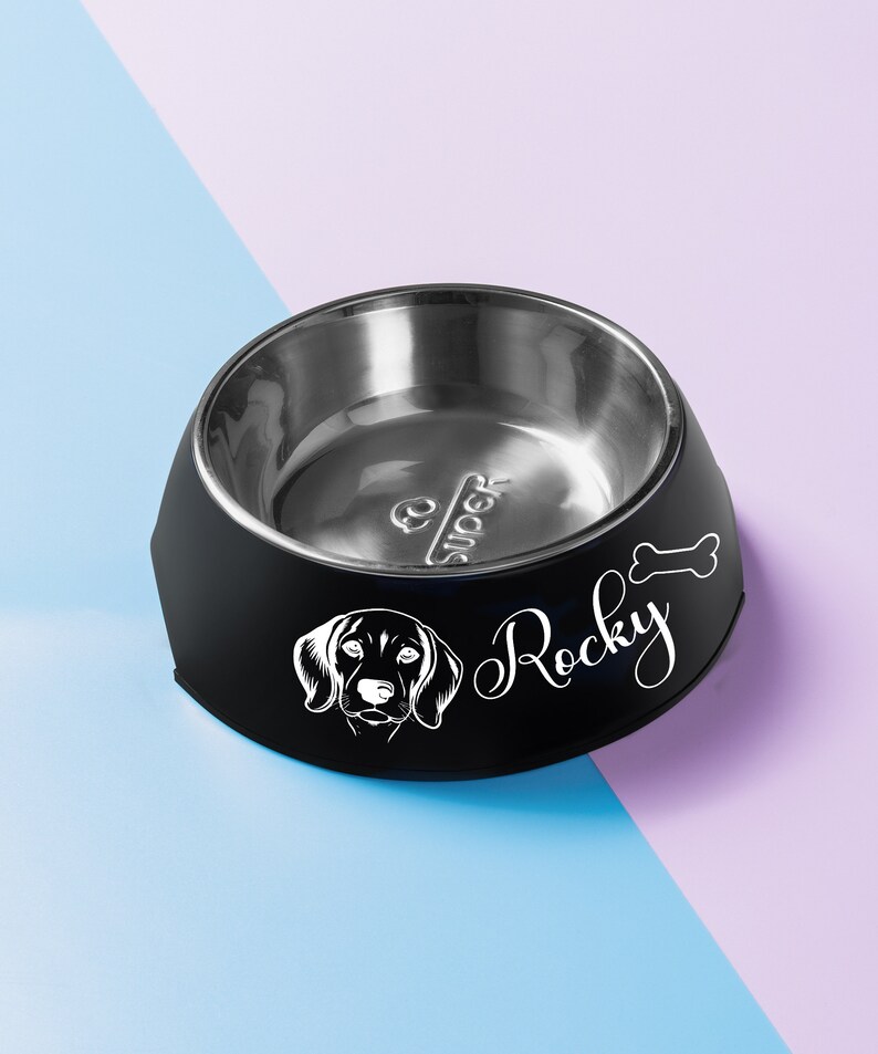 May include: Black and silver dog bowl with a white silhouette of a dog and the name "Rocky" on the side.