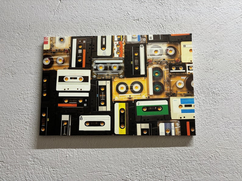 May include: A canvas print featuring a collage of vintage cassette tapes. The tapes are in various colors, including black, white, yellow, and green. The arrangement creates a retro aesthetic, perfect for music lovers and those who appreciate nostalgic decor.