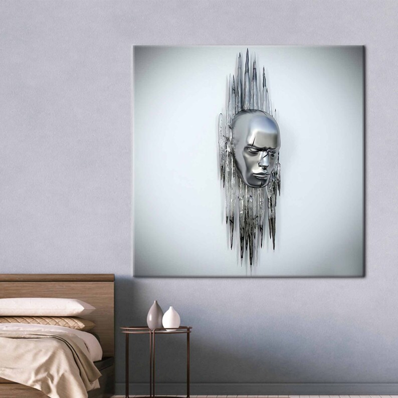 May include: A silver sculpture of a human face with a crown of sharp, pointed metal spikes. The sculpture is mounted on a white wall.