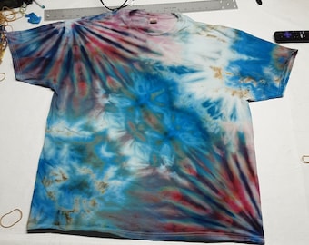 May include: A tie-dye t-shirt with a blue, white, red, and brown swirl pattern. The shirt has short sleeves and a crew neck.