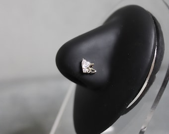 May include: A gold nose ring with a clear heart-shaped stone and a small butterfly design.