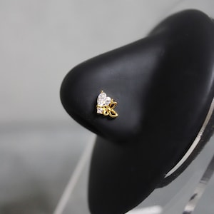 May include: Gold nose ring with a clear heart-shaped stone and a butterfly design.