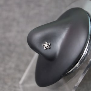 May include: A silver nose ring with a small flower design.