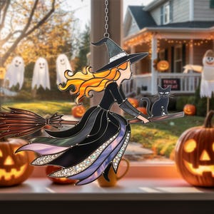 Könnte beinhalten: Halloween-Dekoration aus Glas mit einer Hexe auf einem Besen mit einer schwarzen Katze. Die Hexe hat orangefarbenes Haar und trägt ein schwarzes Kleid und einen Hut. Der Hintergrund umfasst Kürbisse und Geister.
