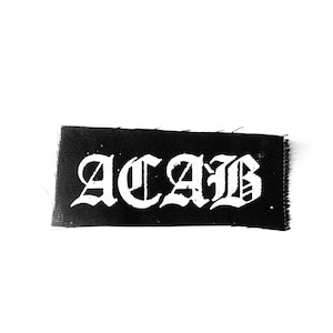 May include: Black fabric patch with white lettering that reads "ACAB" in a gothic font.