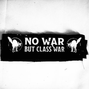 Könnte beinhalten: Schwarz-weiß-Patch mit einer weißen Katzensilhouette auf jeder Seite. Der Text lautet "NO WAR BUT CLASS WAR".