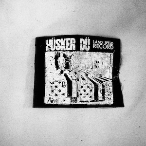 May include: Black and white patch with the text "Whisker Nu Land Speed Record" and a graphic of a person walking down a path with stars on the sides.