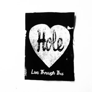 May include: Black and white patch with a white heart shape containing the word "Hole" in a stylized font. The text "Live Through This" is below the heart.