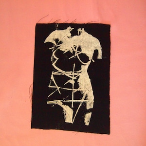 Peut inclure: Un patch en tissu noir avec une silhouette blanche d'un torse humain avec des lignes dessinées dessus.