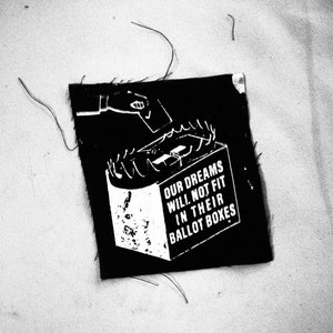 Może przedstawiać: Czarno-biały grafik na czarnym kawałku materiału z tekstem "Nasze marzenia nie zmieszczą się w ich urnach wyborczych".