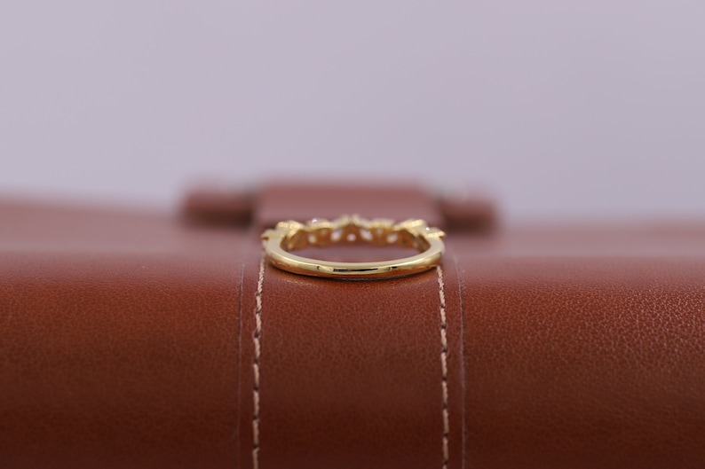 Pu&ograve; includere: Un anello con fascia in oro con piccole pietre trasparenti incastonate nella fascia.