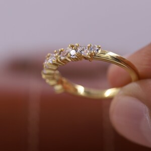 Pu&ograve; includere: Un anello a fascia d'oro con una fila di piccole pietre preziose trasparenti.