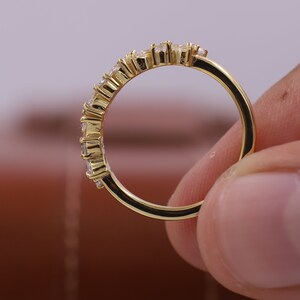 Pu&ograve; includere: Un anello a fascia d'oro con una fila di piccole pietre preziose trasparenti.