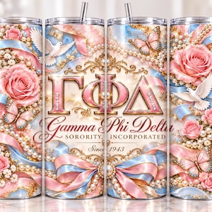 Puede incluir: Un vaso cilíndrico con pajita que presenta un diseño rosa y azul con rosas, perlas, mariposas y palomas blancas. Las letras griegas Gamma Phi Delta están centradas en oro, con el texto Gamma Phi Delta Sorority, Incorporated Since 1943.