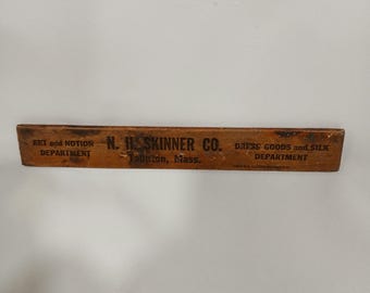 Regla de madera antigua de la tienda departamental N.H. Skinner Co. de Taunton, MA.