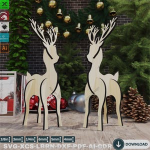 May include: Two wooden reindeer cutouts, standing on a wooden surface. The reindeer are brown and have black outlines. The reindeer are approximately 15 cm tall.