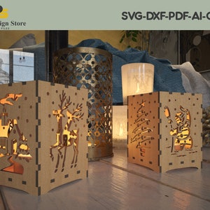 K&ouml;nnte beinhalten: Drei h&ouml;lzerne Weihnachtslaternen-Designs mit Ausschnitten. Die Laternen zeigen ein Rentier, einen Weihnachtsbaum und einen Schneemann. Die Laternen sind von innen beleuchtet und strahlen ein warmes Licht aus.