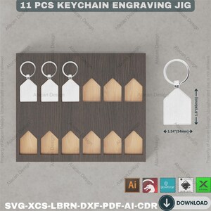 Pu&ograve; includere: Un jig per incisione portachiavi con 11 pezzi. Il jig include portachiavi a forma di casa, alcuni argentati e altri color legno, e una base in legno grigio scuro. Il testo "11 PCS KEYCHAIN ENGRAVING JIG" &egrave; in alto.