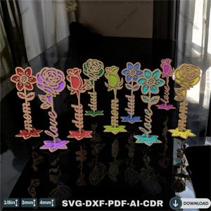 May include: A set of ten laser cut wooden flower designs with different colored flowers and stems. Each flower has a word on the stem, including "mom", "dad", and "love".