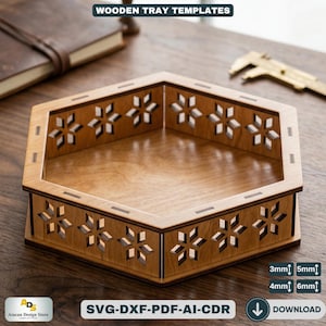 Puede incluir: Una bandeja hexagonal de madera con recortes decorativos de copos de nieve. La bandeja es de madera marrón claro y presenta el texto "WOODEN TRAY TEMPLATES" y "SVG-DXF-PDF-AI-CDR". La bandeja tiene dimensiones de 3 mm, 4 mm, 5 mm y 6 mm.