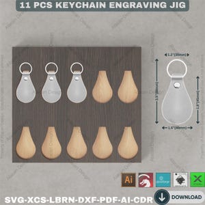 Pu&ograve; includere: Un jig per incisione di portachiavi in legno con 11 pezzi. Il jig include sei forme a goccia in legno e cinque portachiavi argentati a forma di goccia. Le dimensioni del portachiavi sono 45 mm x 40 mm x 88 mm. Il testo "11 PCS KEYCHAIN ENGRAVING JIG" &egrave; in alto.