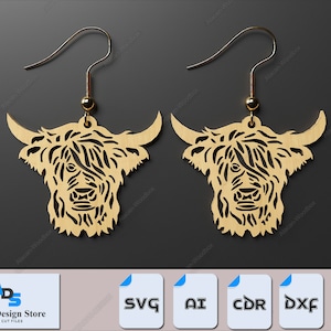 May include: A pair of laser cut wooden earrings featuring a Highland Cow design. The earrings are a light brown color and have a detailed design of the cow's face and fur.
