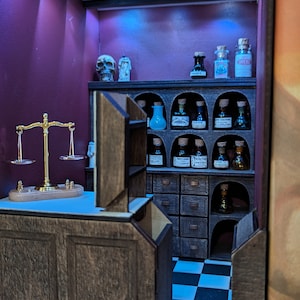 May include: A miniature apothecary shop with a wooden counter, a scale, and shelves filled with glass bottles. The shop has a checkered black and white floor and a wooden ceiling.
