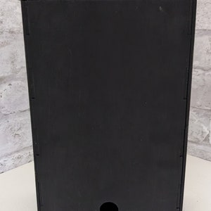 Puede incluir: Caja de pared de madera negra con un peque&ntilde;o agujero en la parte inferior.