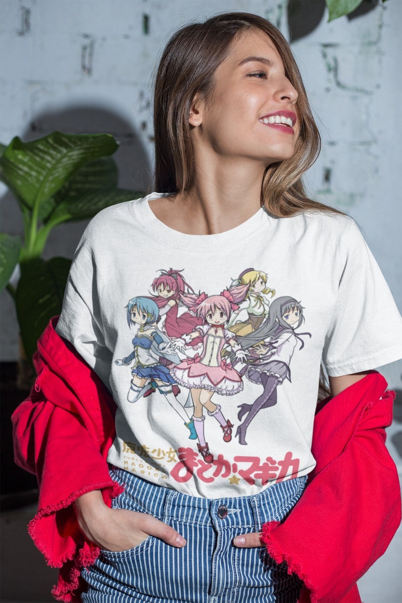 May include: White t-shirt with a colorful anime graphic of five girls in various poses. The text "魔法少女まどか☆マギカ" is printed on the bottom of the shirt.
