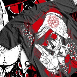 Può includere: Una maglietta nera con un'illustrazione bianca e rossa di un personaggio con occhiali da sole, un cappello e una croce. Il personaggio sta facendo un segno di pace con la mano. L'illustrazione è circondata da un cerchio rosso con un pentagramma e testo in una lingua straniera.