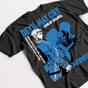 Peut inclure: T-shirt noir avec une illustration bleue et blanche de deux personnages du jeu vidéo Devil May Cry. Le texte "Devil May Cry", "Son of Sparda", "Power controls everything... and without power you cannot protect anything", et "Vergil" est imprimé sur le t-shirt.