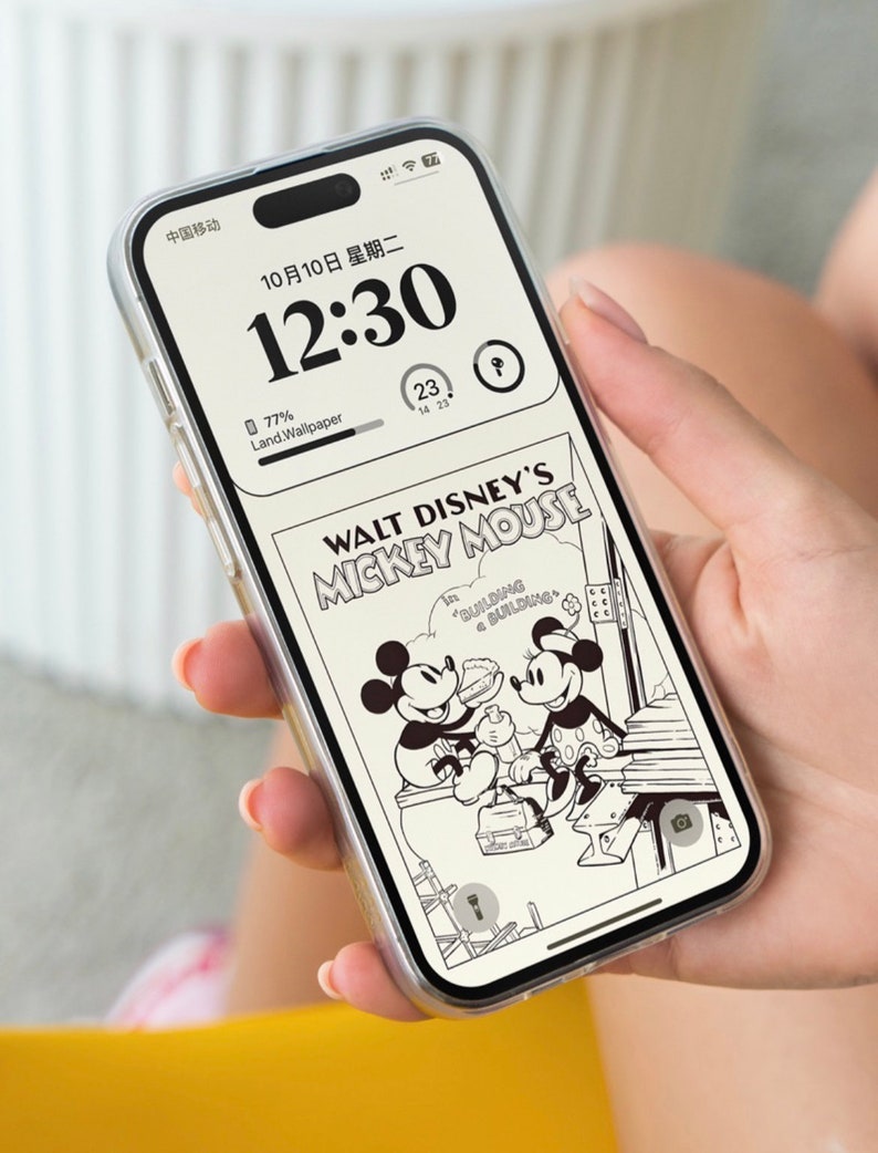 K&ouml;nnte beinhalten: Eine transparente Handyh&uuml;lle mit einer Schwarzwei&szlig;illustration von Mickey Mouse und Minnie Mouse aus einem Walt Disney Comic. Die Handyh&uuml;lle hat einen schwarzen Rand und eine transparente R&uuml;ckseite. Die Handyh&uuml;lle befindet sich auf einem Handy mit einem schwarzen Bildschirm, auf dem die Uhrzeit 12:30 und das Datum 10/10 angezeigt werden. Das Handy wird von einer Hand gehalten.