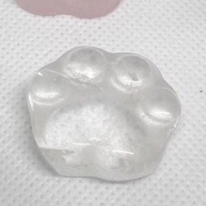 May include: Six paw print shaped stones in various colors, including green, pink, clear, and black.