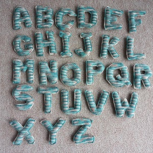 Letra del alfabeto tejida a crochet hecha a mano en diferentes colores y tamaños