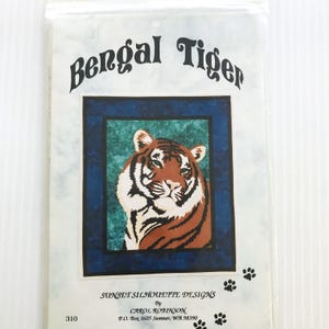 May include: A package featuring a Bengal tiger design. The tiger is depicted with orange and black stripes, set against a blue and green background. The text "Bengal Tiger" is arched above the image. The package also includes the text "Sunset Silhouette Designs" and the number "310".