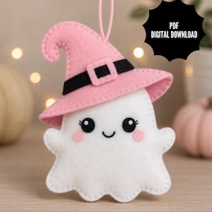 May include: A white felt ghost ornament wearing a pink witch hat with a black band and buckle. The ghost has black eyes, a small smile, and pink cheeks. A pink string is attached to the top. The text PDF DIGITAL DOWNLOAD is visible.