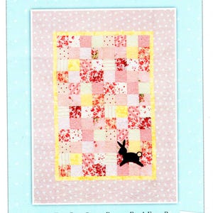 May include: A quilt pattern titled "Patchwork Rabbit" with a finished size of 38" x 50". The quilt design features a patchwork of pink, red, and yellow squares, with a black rabbit silhouette. The text "Stitch Studios" is also visible.