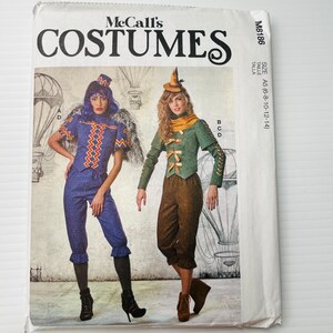 May include: McCall's Costumes pattern featuring two costume designs. One costume is blue with orange zig-zag accents, the other is green and brown. The pattern includes sizes A5 (6-8-10-12-14).